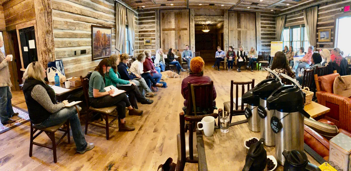 People seated in a circle, talking together at a Hopa Mountain gathering.